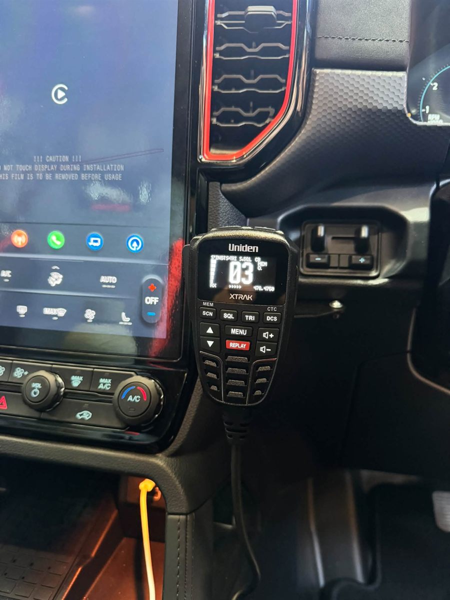 Uniden XTRAK UHF handset mounted beside the infotainment screen