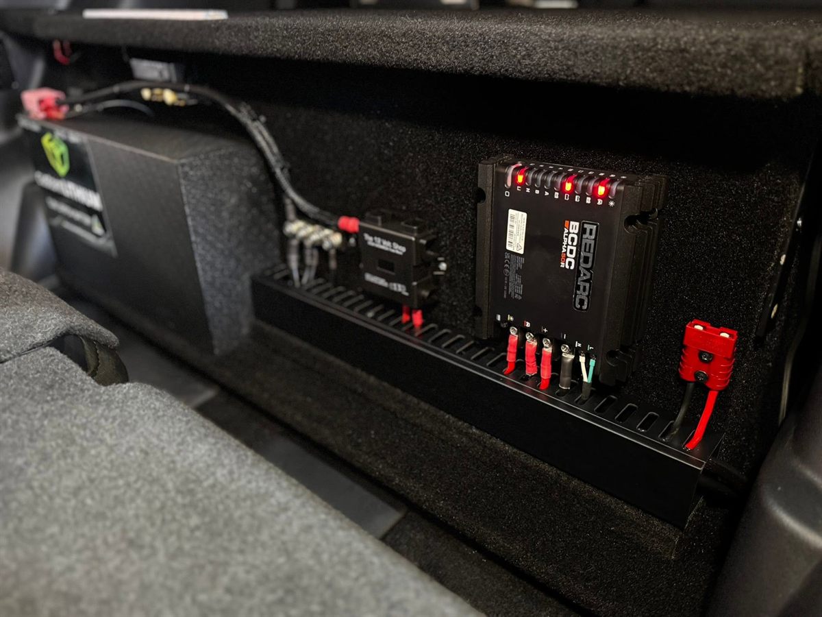 REDARC BCDC DC-DC charger with neatly terminated wiring beside a Custom Lithium battery