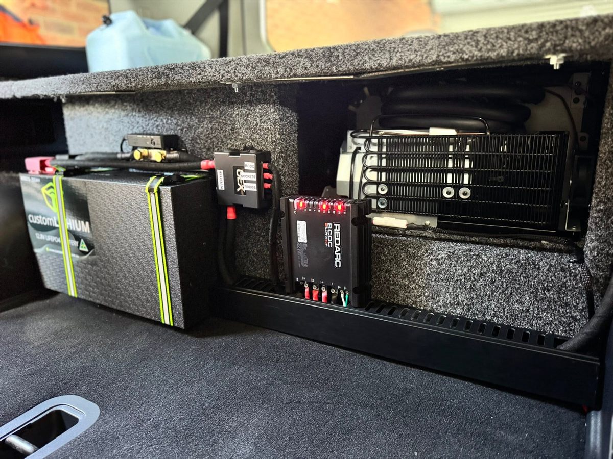 Custom Lithium battery, REDARC BCDC charger and fused distribution beside a slide-out fridge