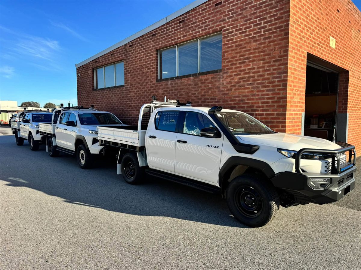 Fleet of new Hilux tray-backs outside the workshop